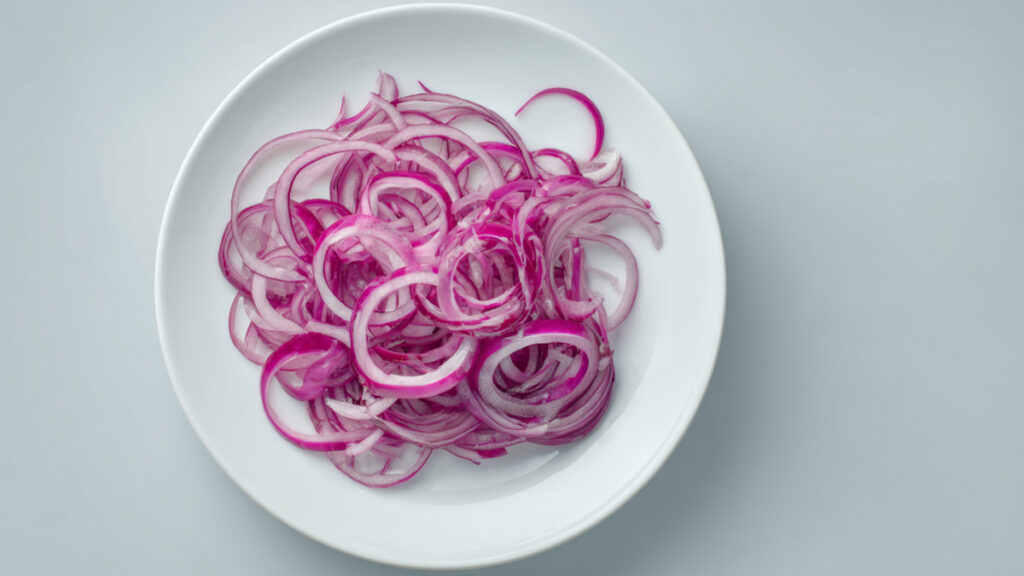 Plate of thinly sliced red onions.
